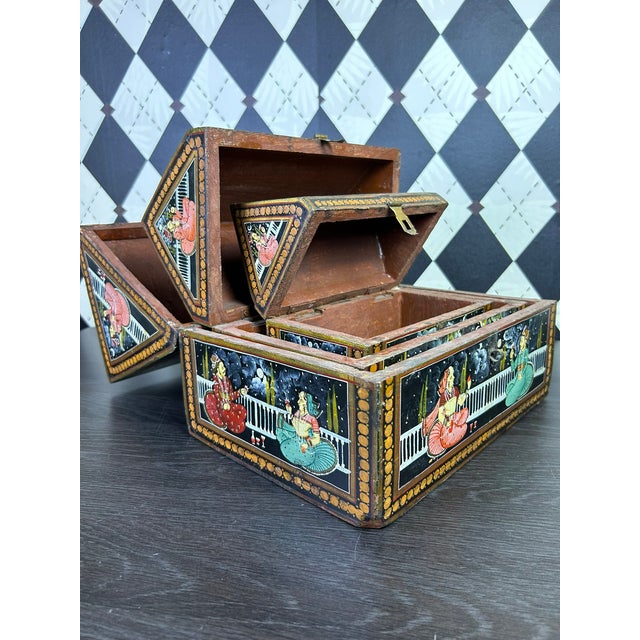 Set of three graduated and nesting vintage Indian wooden nesting boxes with hand-painted figural decoration. Each box has...