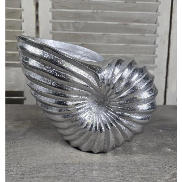 A striking sculptural champagne cooler cast in aluminium in the form of a large nautilus shell. The beautifully modelled...