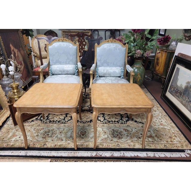 Find pair of vintage Country French end tables in blonde wood with shell carvings and slender cabriol legs. Each measures...