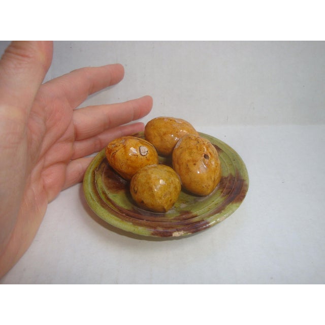 Delightful rustic European small scale antique majolica plate stacked with 4 life-size nuts, which I believe to be either...