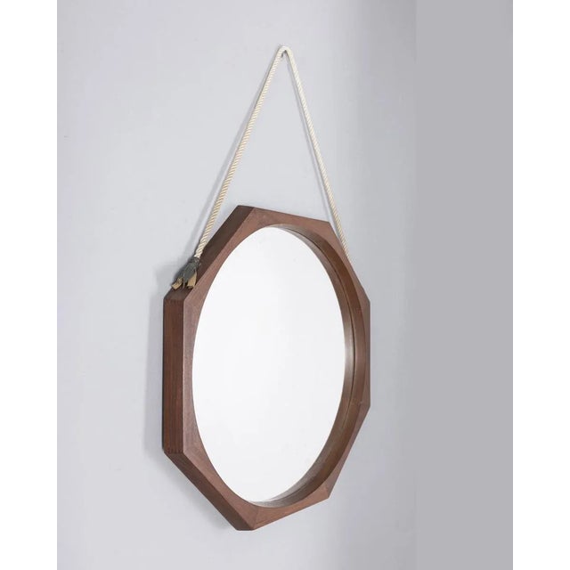 Octagonal wall mirror with wooden frame, with cord for hanging it on the wall, 1960s.