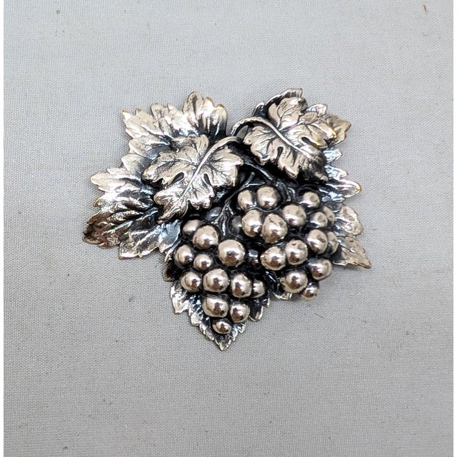 Circa 1960s silvertone repoussé grape cluster with dye to give a 3d look with leaves brooch with security clasp. Marked...