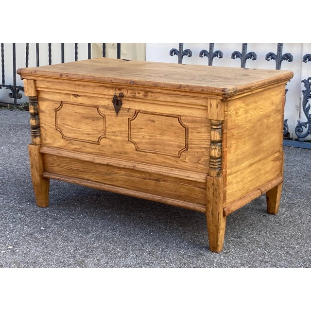 A bold ogee molding is pegged onto the edge of the top of this handsome trunk.. The top lifts on iron strap hinges, to...