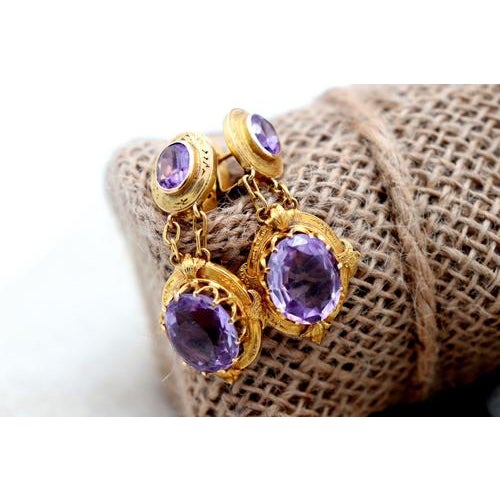 Gold earrings with reliefs involving amethysts cut in a tilting shape. Metal: Gold. Origin: European. Mark: Absent....