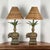 A striking pair of British Colonial–style table lamps featuring elaborately draped elephant bases with rich gilt accents...