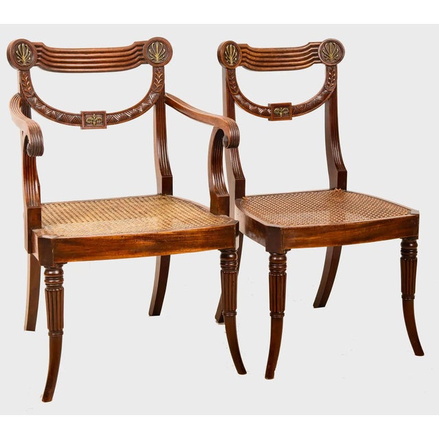 Set of ten rare and fine period Regency chairs in carved mahogany. Neoclassical draped form with applied ormolu mounts of...