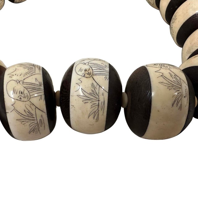 This is a hand-strung mala necklace/rosary featuring large, barrel-shaped bone beads with intricate hand-carved and...