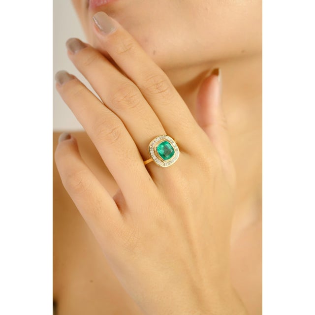Elegantly crafted in 18k yellow gold, this stunning ring showcases a vivid 1.72-carat cushion-cut emerald at its center —...