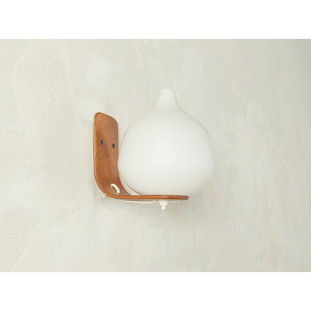 Rare 1960s Scandinavian-style wall lamp by Uno & Östen Kristiansson for Luxus. The lamp features a frosted glass shade...
