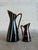 This pair of versatile ceramic pieces seamlessly doubles as either small bud vases or candleholders, showcasing a striking...