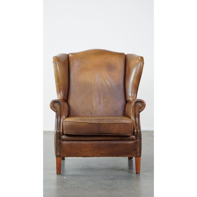 This charming sheep leather wing chair with a beautiful patina and good seating comfort. This fantastic. correctly...