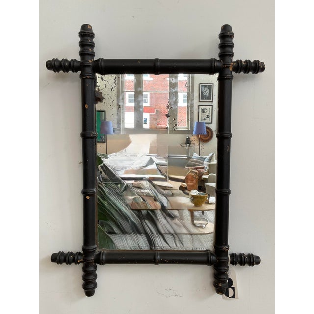 A charming early 20th-century French Provincial wall mirror featuring a hand-turned wood frame crafted in imitation of...