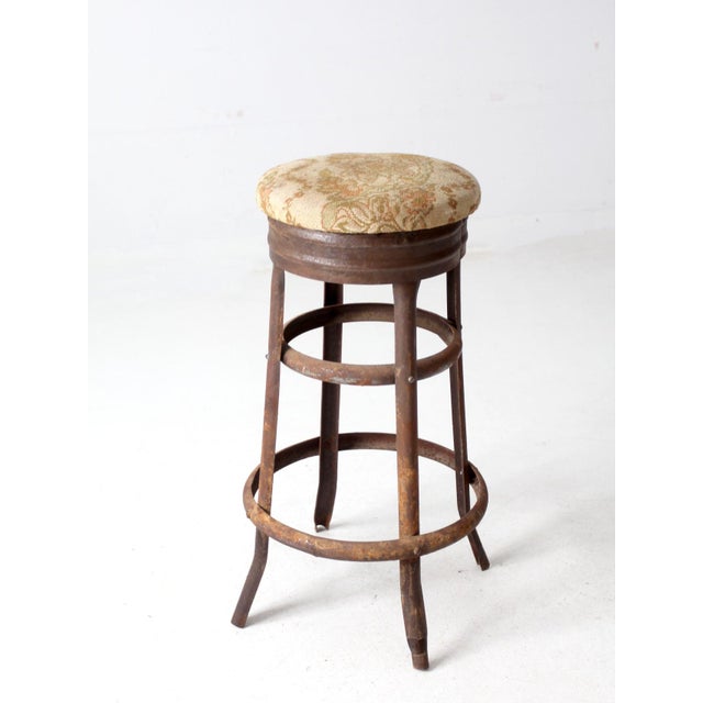 This antique metal stool is a stylish blend of industrial and rustic design. Its weathered finish adds a touch of...