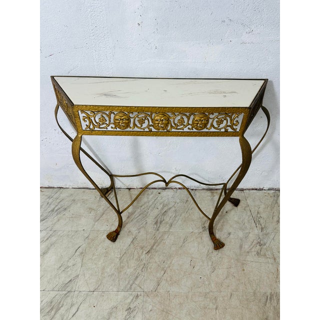 This is a charming vintage metal console table with a strong antique character. The piece features a narrow, rectangular...