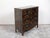An English black commode from the 19th century, with Chinoiserie low-relief décor, guilloche motifs and five drawers....