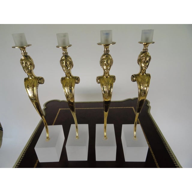 Set of four female figure Italian bronze candleholders featuring beautiful details. Carved breast-plate detail mounted on...
