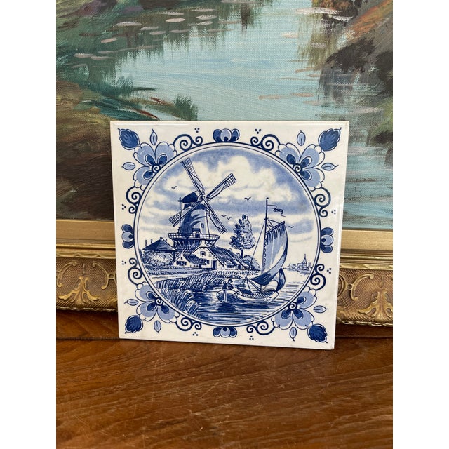 Charming hand-painted Delft blue ceramic tile by Schoonhoven Keramiek of Holland, featuring classic Dutch pastoral scene...