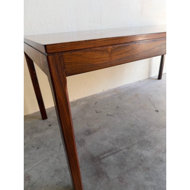 Danish Mid-Century Modern coffee table crafted in rich rosewood, showcasing stunning natural grain and timeless...