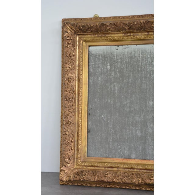 K0516 a superb french antique gilded wall mirror with extensively foxed glass in profusely carved and highly decorative...