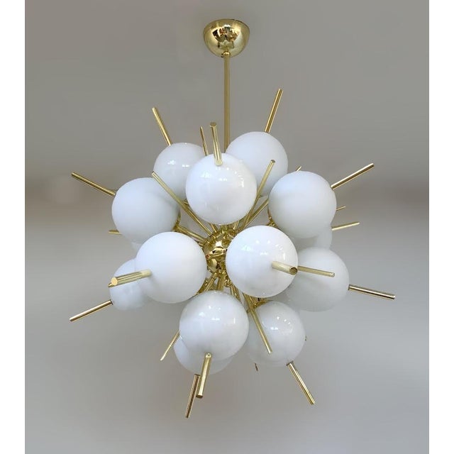 Italian sputnik chandelier with 18 Murano glass globes and brass cylinder spikes mounted on metal frame in light gold...