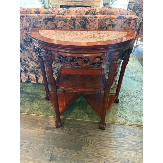 Striking vintage Chinese-style carved hardwood demilune console featuring a beautiful inset marble top. The elegant half...