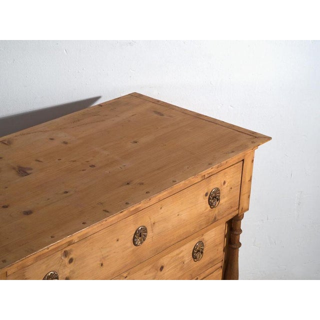 This antique chest of drawers in solid pine is a storage piece from Central Europe dating to the early 20th century,...