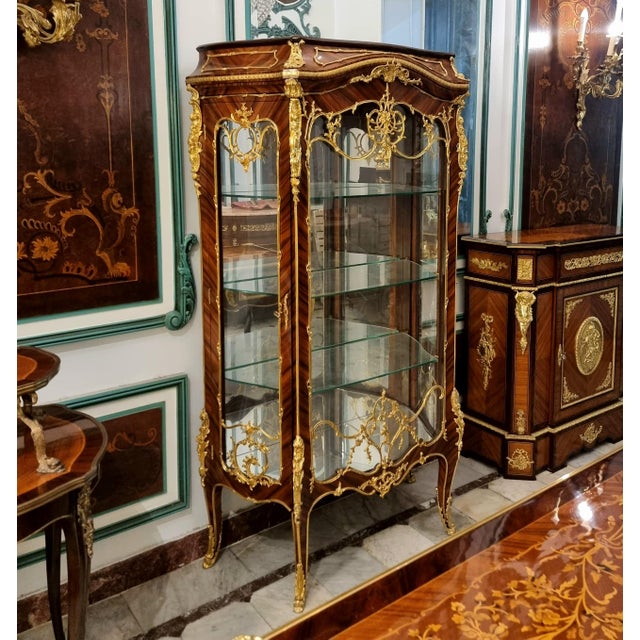 Showcase your most treasured collectibles in this magnificent French Louis XV Curio Display Cabinet, a luxurious statement...