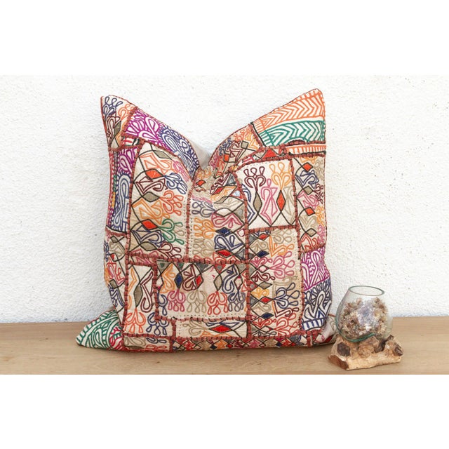 This 22-inch square pillow is a breathtaking example of Rajasthani textile art, handcrafted from rare antique Banjara...