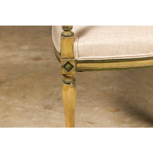 A French Directoire settee from the 19th century with soft creamish yellow painted finish, green accents, painted garlands...