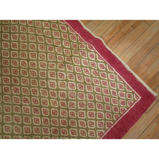 One of a kind vintage Turkish rug with a tight repetitive pattern in raspberries on a camel brown field. 4'1'' x 6'7''