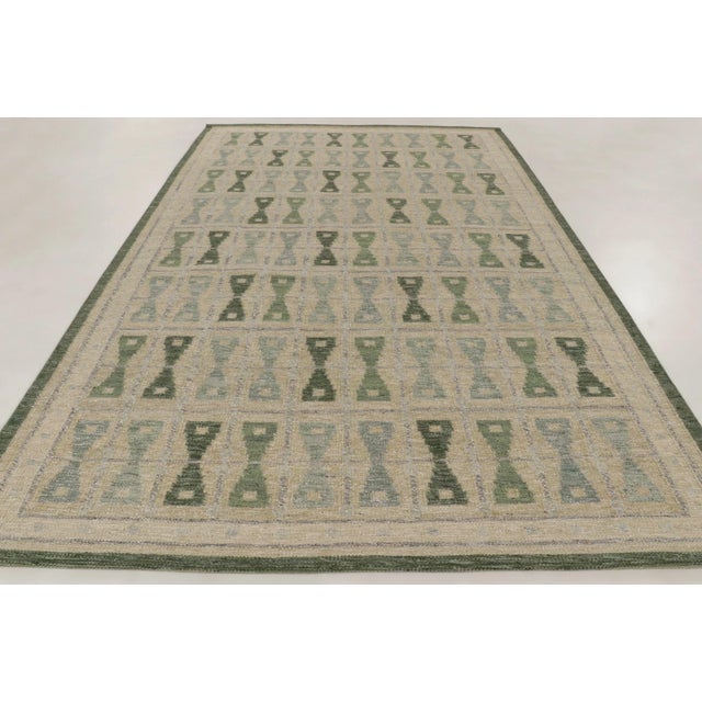 gHandwoven in wool and natural yarn, this 8x13 Scandinavian rug features a repeating geometric pattern in calming shades...
