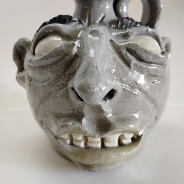 This piece is an original, handmade folk art face jug created by the contemporary Georgia potter and educator Stephen...