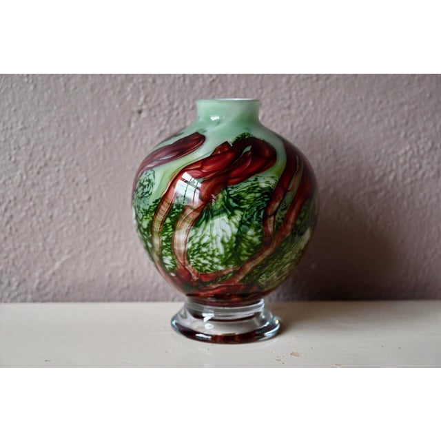Simply captivating, this Murano blown glass lamp base immediately draws the eye with its swirls of burgundy red that curl...