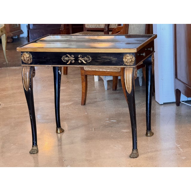 Napoleon III period side table with ebonized finish and gilt detailing. Features include a single drawer, lion mask mounts...