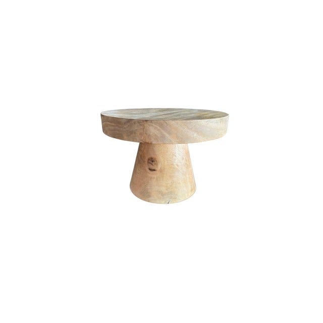 Crafted from solid suar wood, this round side table showcases the natural beauty and fluid character of the timber in its...