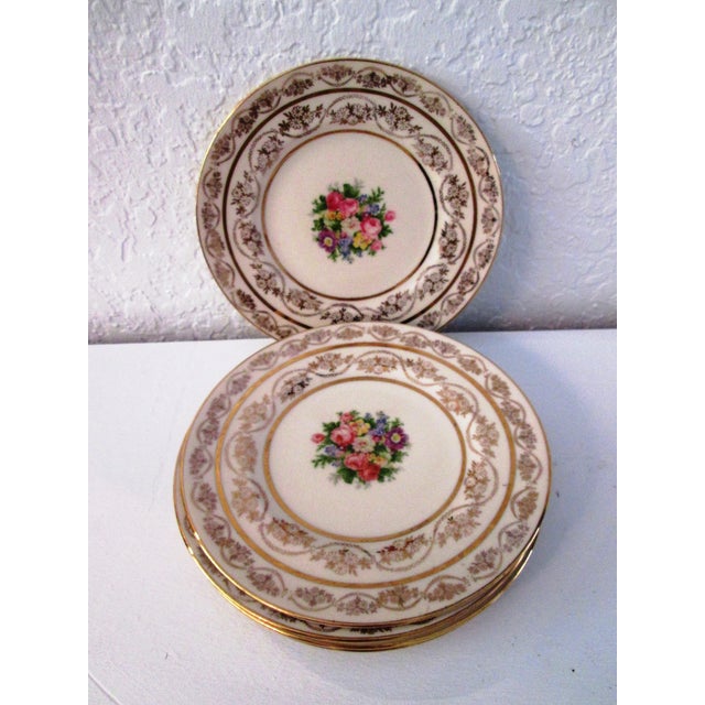 Mid-century set of six Atlas China porcelain dessert/salad/bread plates featuring a floral design in center with 22 karat...