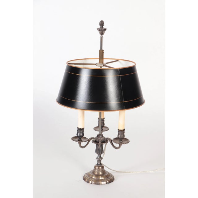 A silver plate Louis XVI style three branch Bouillotte lamp with a tole shade circa 1900.