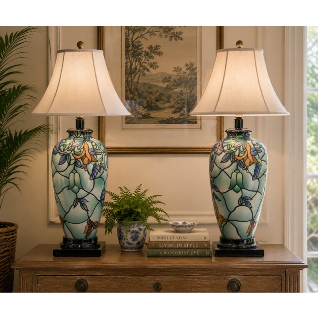 An elegant pair of Art Nouveau-inspired ceramic table lamps featuring gracefully proportioned ovoid bodies decorated with...