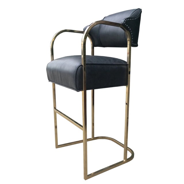 GREAT - Minor wear consistent with age and history Pair of limited edition polished brass bar stools upholstered in black...