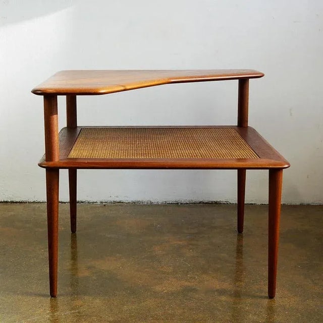 This rare, two-tiered Minerva teak corner side table was designed by the iconic design duo Peter Hvidt and Orla Mølgaard-...