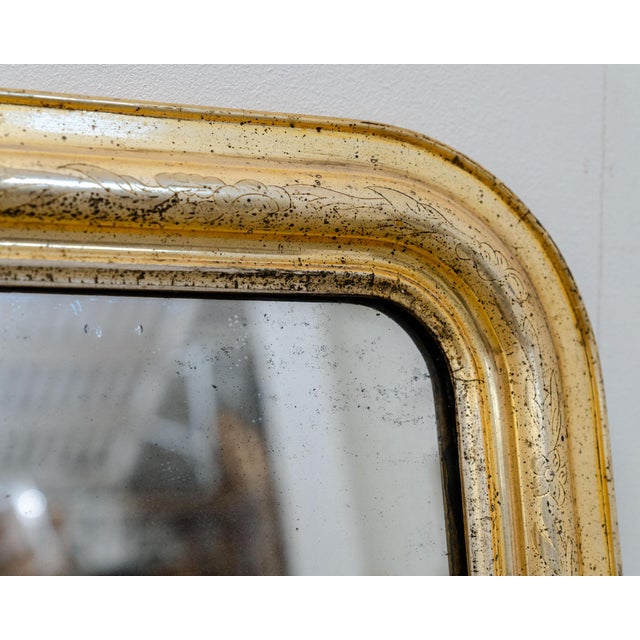 Antique Louis-Philippe mercury mirror from the late 19th century. Its wooden frame displays lovely tones and beautiful...