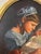 Oval shaped oil painting "The Quilter" by Susan Shank, produced in 1993 in Carlisle, Pennsylvania. This painting shows a...