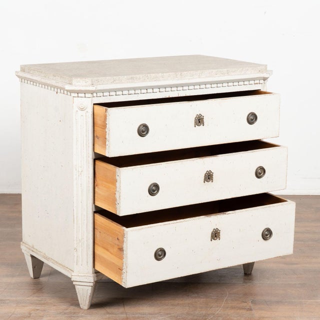 Early 19th century Swedish Gustavian chest of three drawers, crafted in pine. The case is detailed with canted fluted...