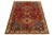 Vintage hand-knotted wool rug with a red field and multicolor geometric design. This rug measures 3'9'' x 5'5''.