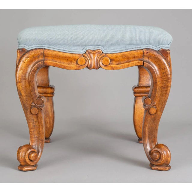 Early Victorian carved and molded bird’s eye maple stool with cabriole legs ending in scroll feet on pads. Upholstered in...
