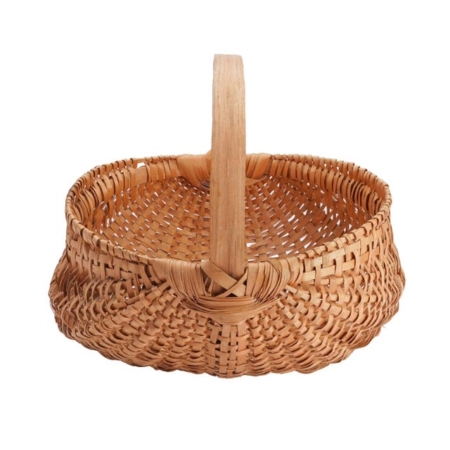 Large hand woven buttock basket. Splines and hand carved ribs of swamp birch with a fixed hickory loop handle. Early 20th...