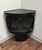 A fun Mid-Century black faux fireplace that fits into a corner. This non vented decorative fireplace has cetamic faux logs...