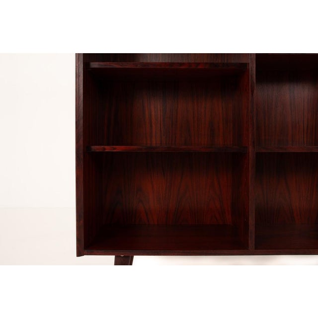 Elegant Danish mid-century bookcase in richly grained rosewood veneer, dating from the 1960s. The piece features a...