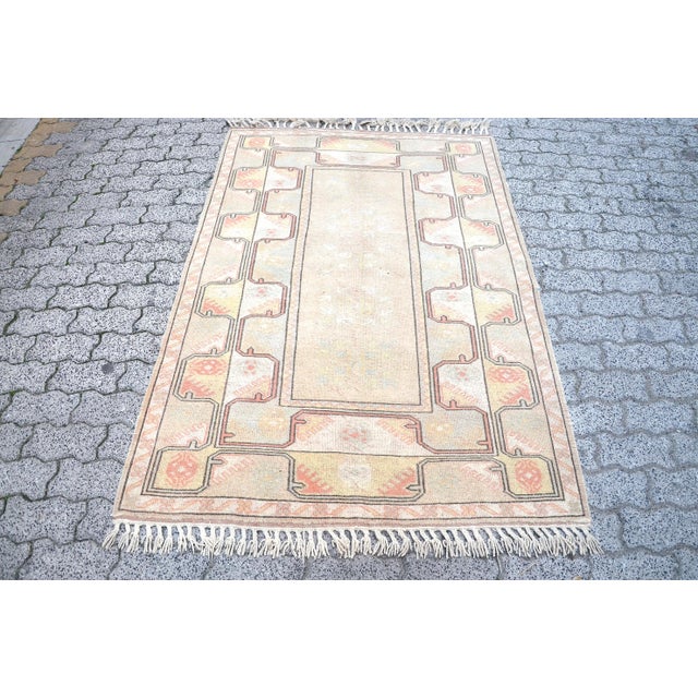 This is a vintage Turkish Oushak rug from the 1960s. The piece was hand-knotted.