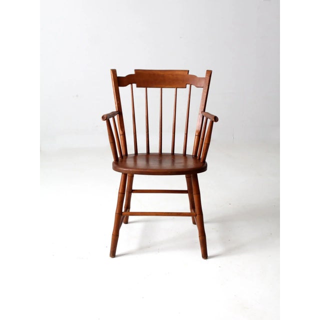 This is a mid-20th century Conant Ball dining chair. The sleek arm chair is a modern Windsor style chair with spindle...